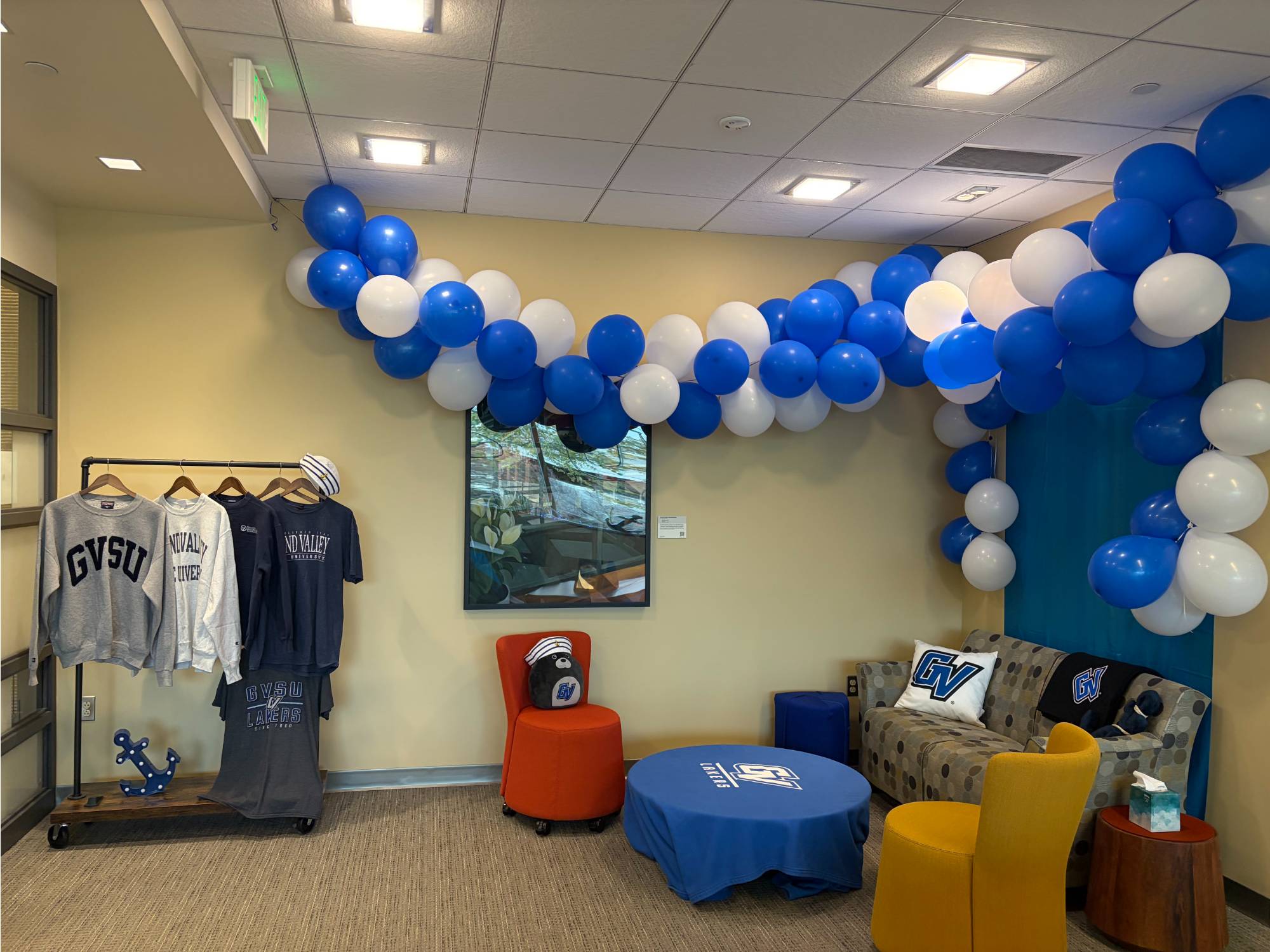 Balloon arch and other GV decorations around a small couch